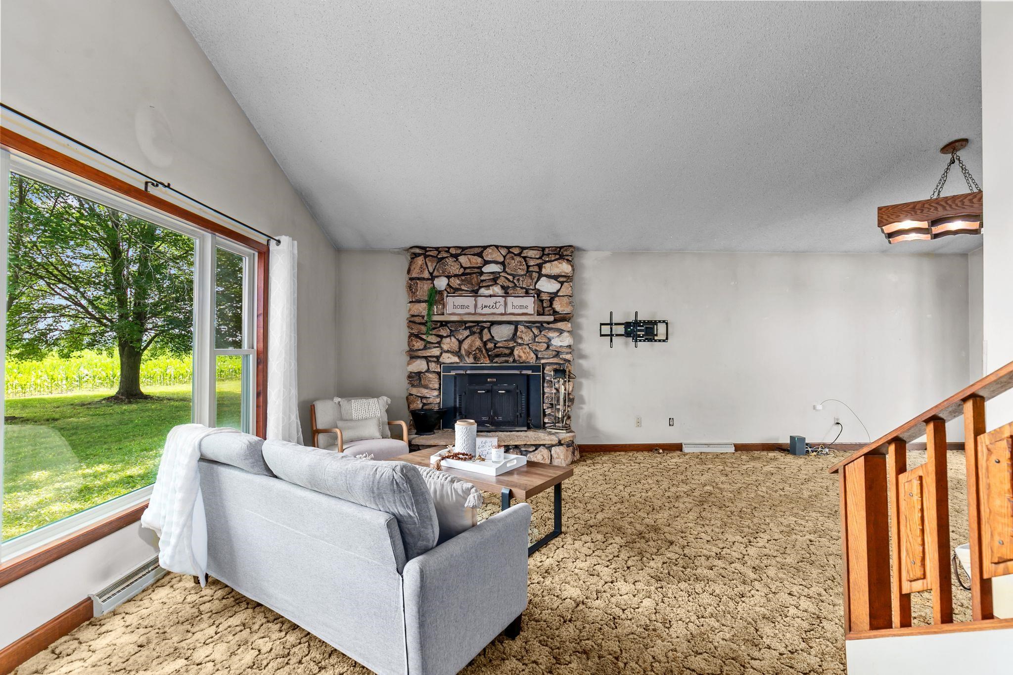 Living room w/ high ceilings and cozy wood burning fireplace