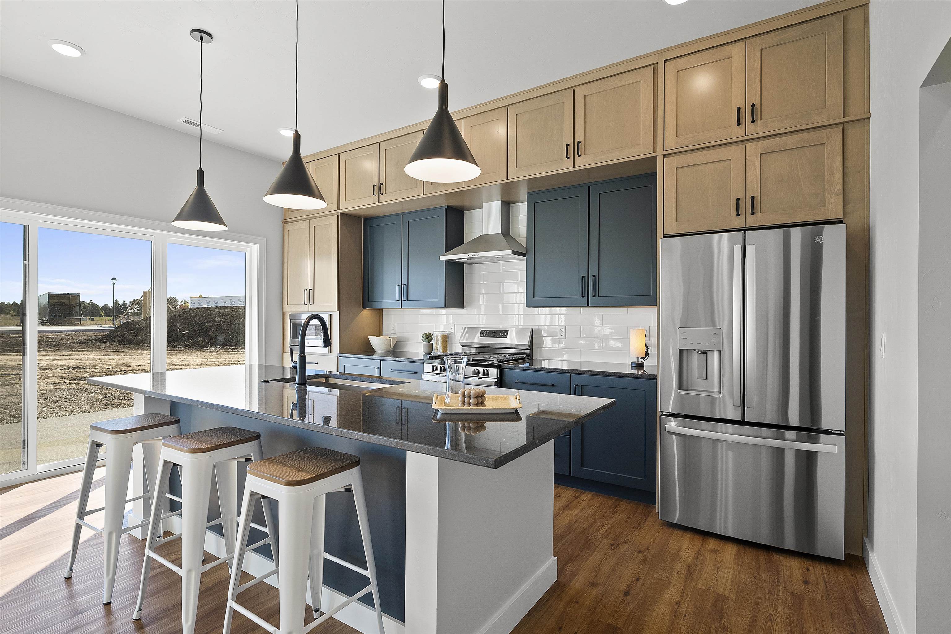 Kitchen shows 'traditional' interior design w/combination stain/paint cabinets & oversized island