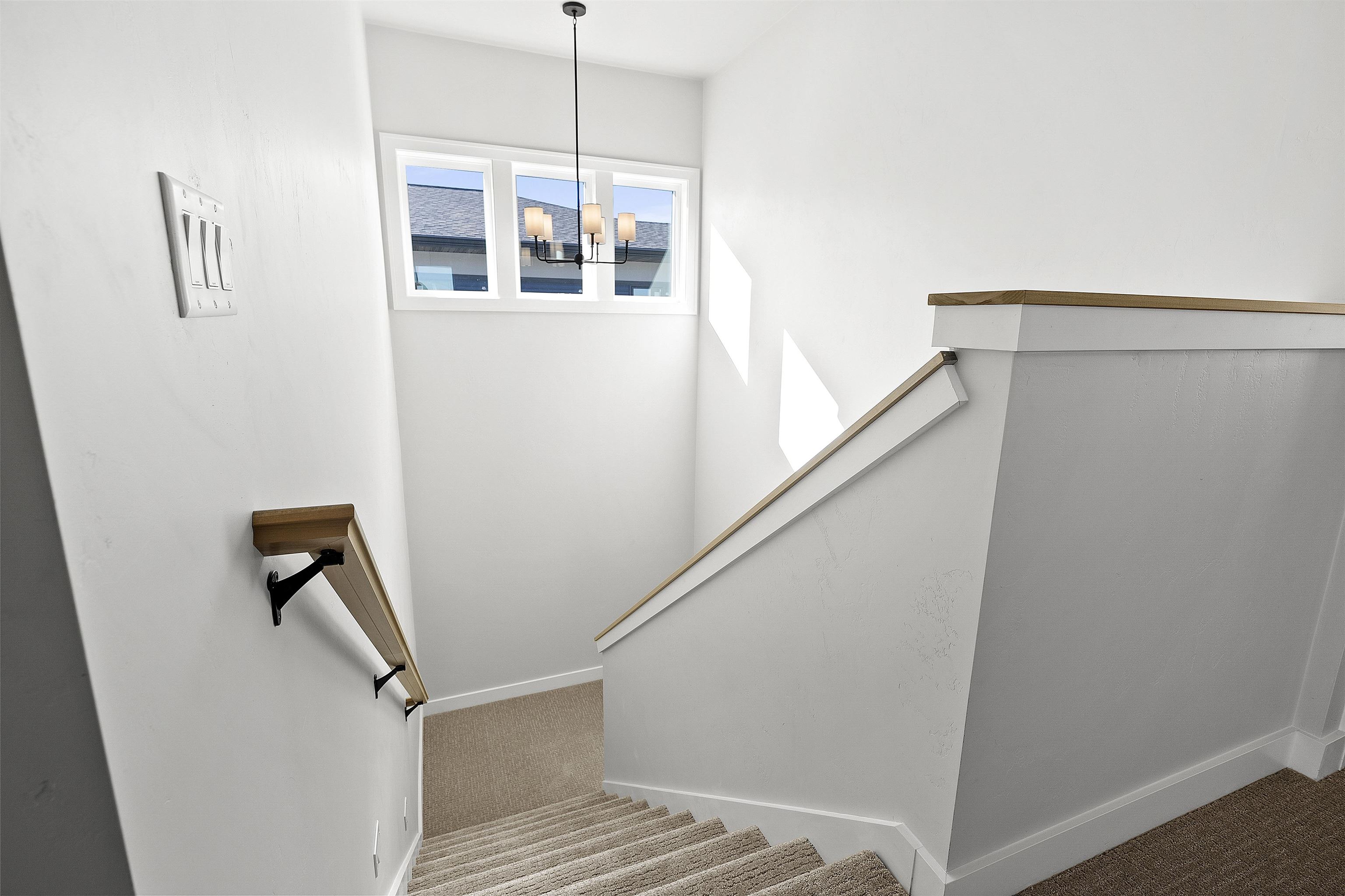 Stairway with landing, chandelier, step lights and natural lighting